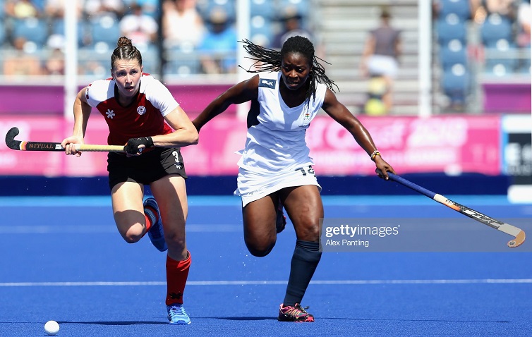 Ghana defender Mavis Berko tackles Canada midfielder Katherine Wright uring the Women's hockey pool